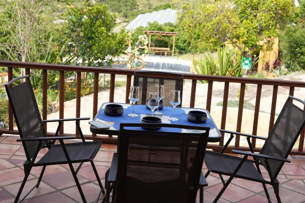 Mesa puesta en el balcón de la casa, con vista a los árboles