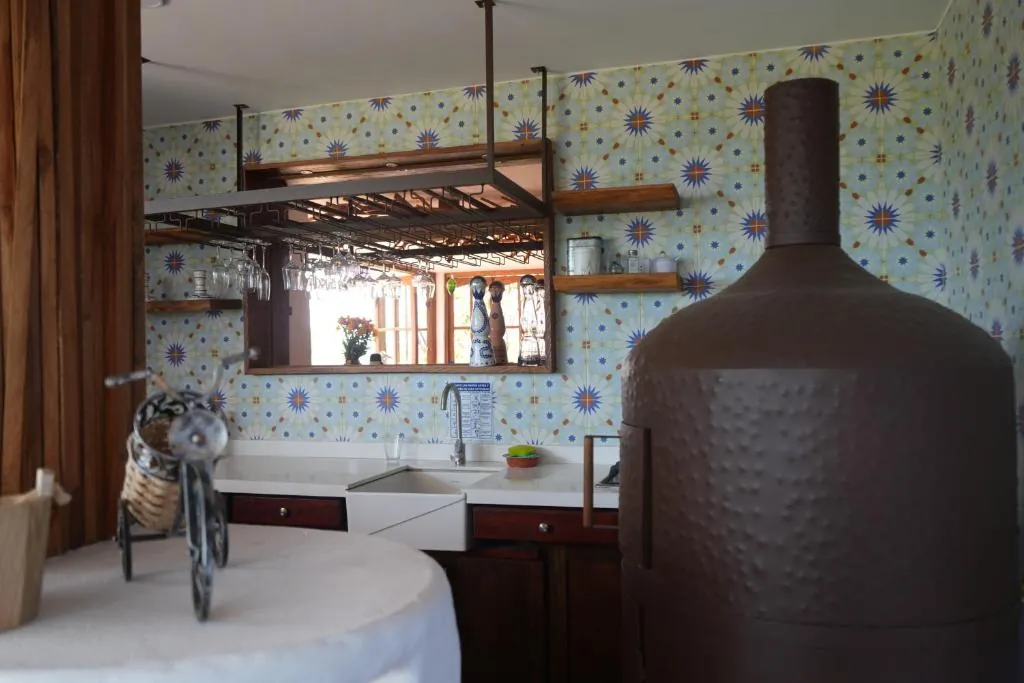Cocina de la casa con enchape de azulejos y copas colgadas