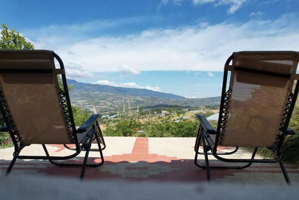 Dos sillas reclinables en la terraza, frente al valle y las montañas