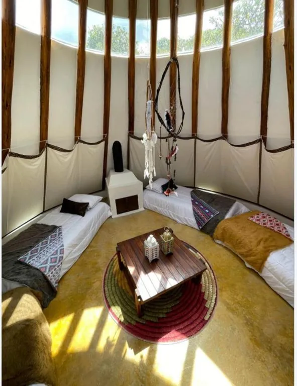 Tipi visto desde arriba, con camas alrededor y mesa al centro